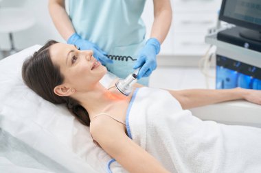 Kadın güzellik merkezinde radyoterapi görüyor.