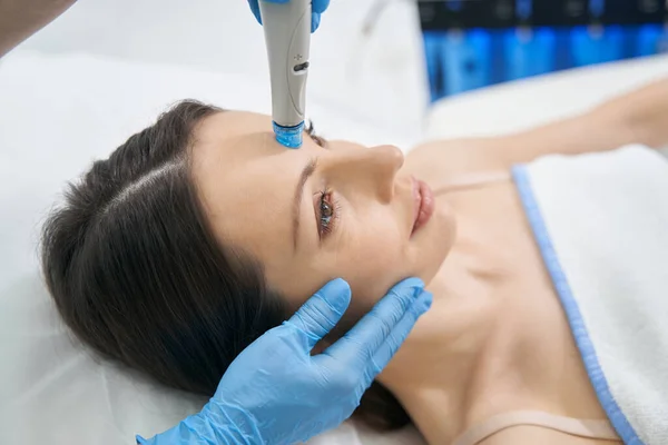 Vrouw die hydraulische gezichtsbehandeling krijgt in schoonheidskliniek — Stockfoto