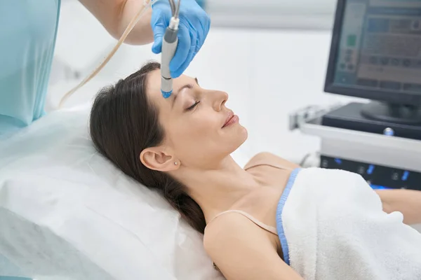 Femme ayant une procédure de lifting du visage dans une clinique de cosmétologie — Photo
