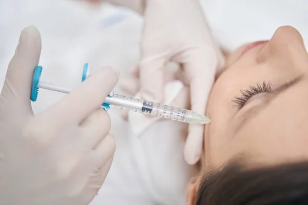 Cosmetólogo haciendo rejuvenecedora inyección facial en mejilla de mujer —  Fotos de Stock