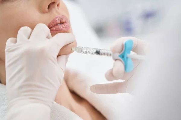 Médico cosmetólogo haciendo inyección de belleza en la barbilla de la mujer —  Fotos de Stock