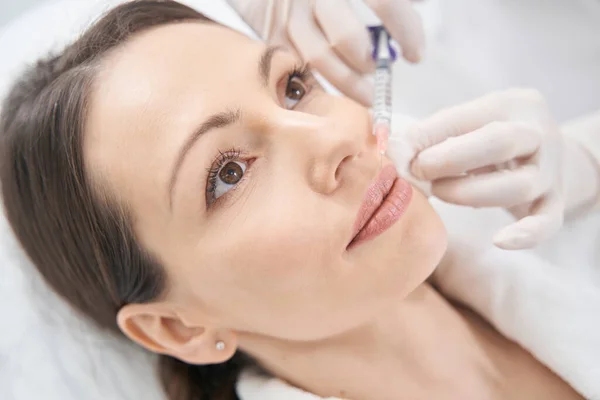 Doctor cosmetoloog het maken van schoonheid injectie in vrouwelijke lippen — Stockfoto