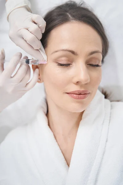Vrouw ontvangt gezicht tillen injectie in schoonheidssalon — Stockfoto