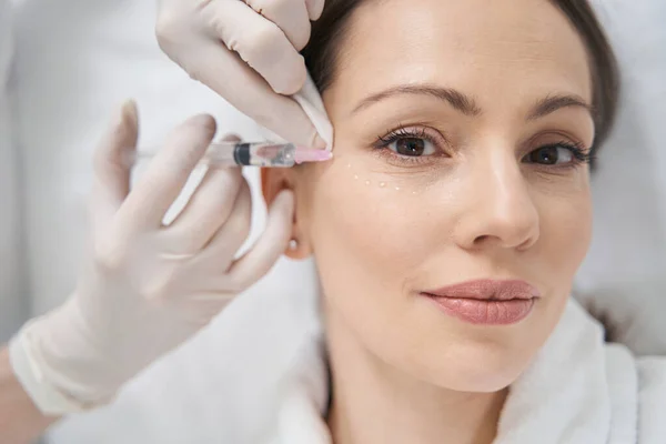 Kosmetolog wykonujący wstrzyknięcie plastyczne konturu w twarz kobiety — Zdjęcie stockowe