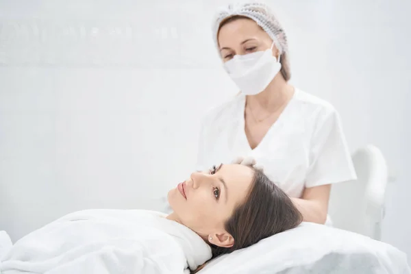 Femme recevant un traitement facial dans une clinique de cosmétologie — Photo