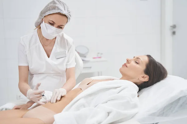 Frau erhält Bauchstraffungsspritze in Kosmetologie-Klinik — Stockfoto