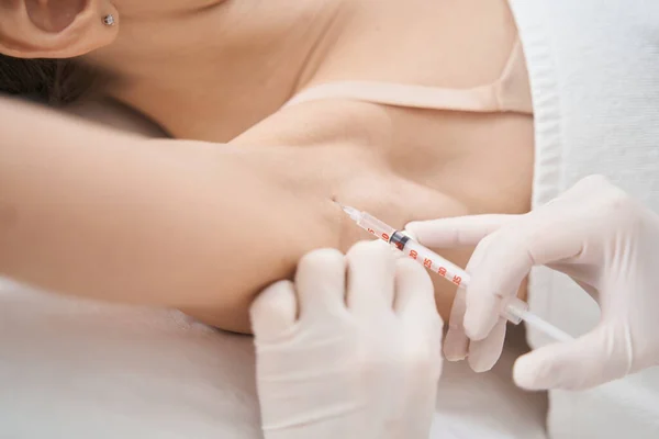 Mujer recibiendo inyección de axila en salón de belleza —  Fotos de Stock