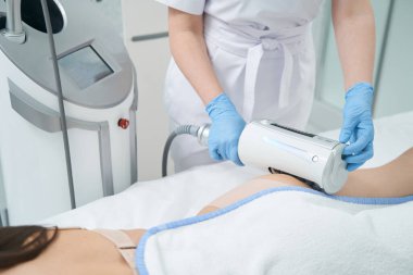 Beautician eliminating butt cellulite of beauty parlor visitor with endosphere device