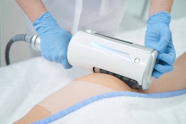 Kadın hastaların kalçalarındaki selülitlerden kurtulmak için güzellik terapistine Endosphere masaj aleti.