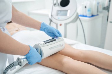 Kalça bölgesindeki selülitlerin azaltılması için endosfer masaj aleti kullanan güzellik salonu çalışanı.