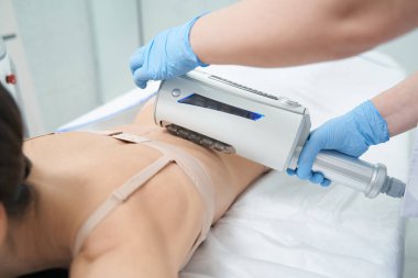 Kozmetik uzmanı, güzellik salonundaki kadına son noktayı koymak için sıkıştırıcı mikrotitreşim masajı yapıyor.