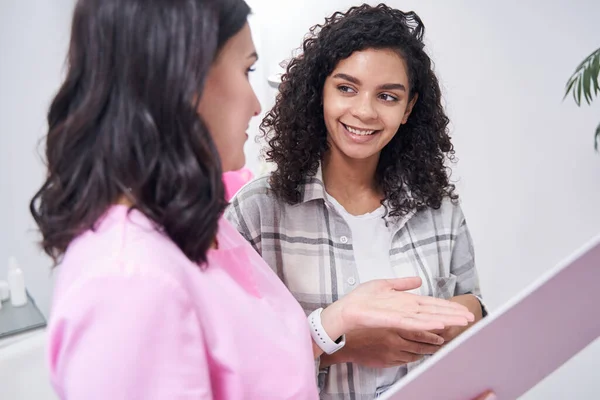 Two women are standing side by side with a document — Stock Photo, Image