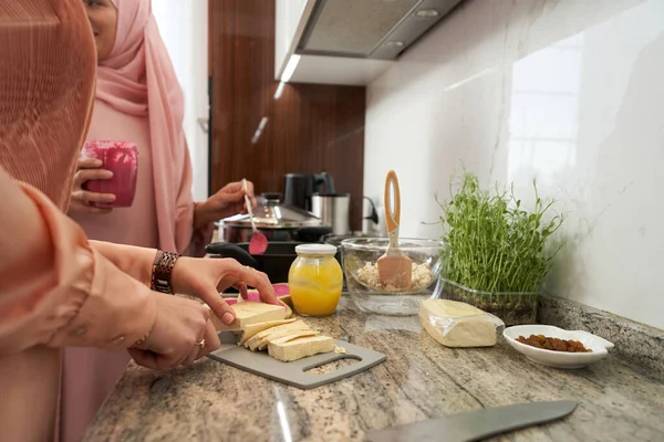 Мусульманка ріже сир на кухні. — стокове фото