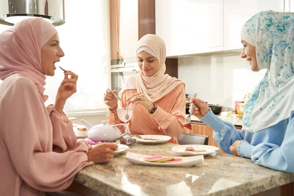 Mulheres muçulmanas almoçando juntas na cozinha — Fotografia de Stock