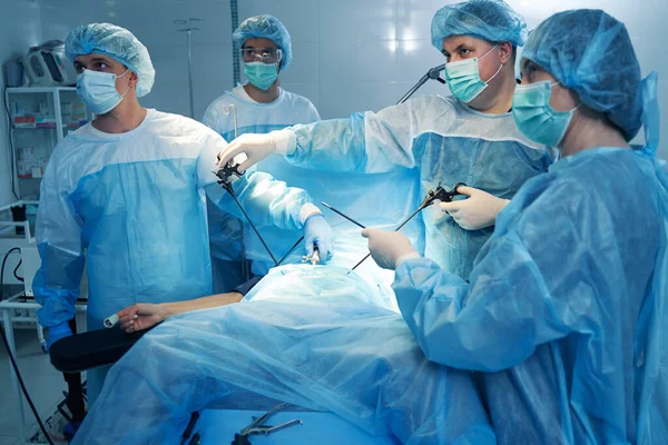 Grupo de cirurgiões operando em paciente em sala cirúrgica — Fotografia de Stock