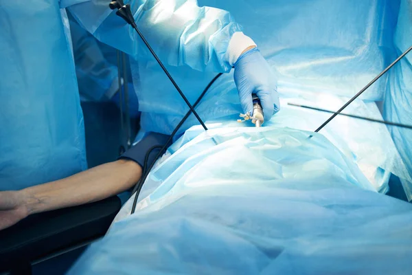 Mano del medico che mette la macchina fotografica chirurgica dentro l'addome paziente — Foto Stock