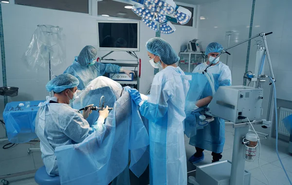 Dört cerrahi uzmanı hastayı tedavi ediyor. — Stok fotoğraf