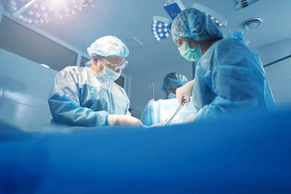 Médecins faisant des travaux chirurgicaux en salle d'opération — Photo