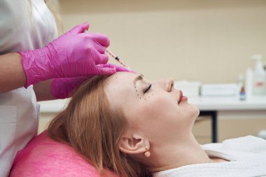 Zarif dişinin yan görünüm portresi göz çevresindeki kırışıklıkları yumuşatıyor.