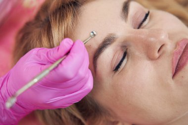 Güzel bir kadının üst görünüm portresi estetik merkezde profesyonel cilt temizliği alıyor.