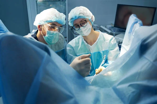 Ung Kvinnlig Sjuksköterska Skär Patientvävnad Bäckenområdet Med Kirurg Som Kontrollerar — Stockfoto