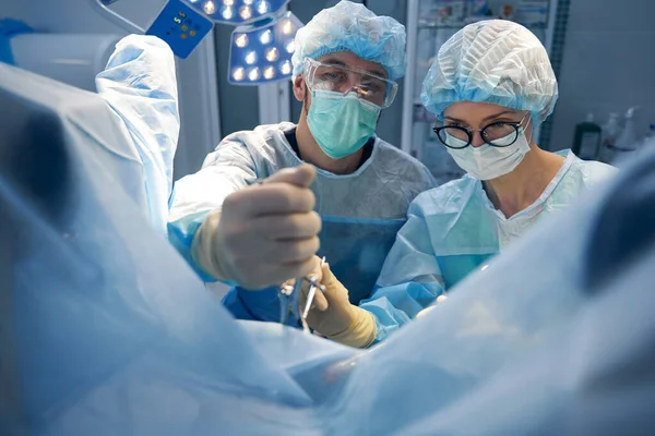 Médico Masculino Segurando Tecido Incisão Com Pinça Bloqueada Enquanto Enfermeira — Fotografia de Stock