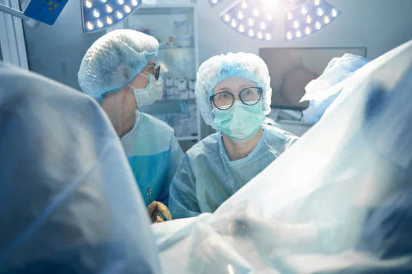 Médico Feminino Lado Enfermeira Olhando Algum Lugar Enquanto Tratava Paciente — Fotografia de Stock