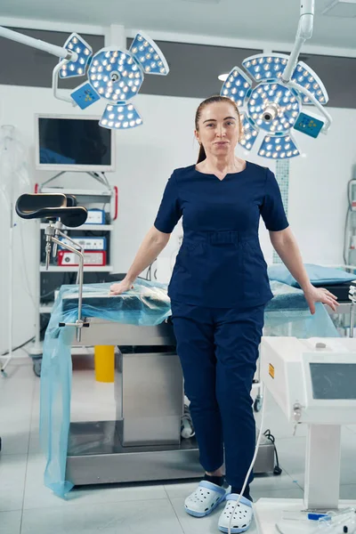 Mulher Branca Feliz Médico Colocando Mão Mesa Cirúrgica Enquanto Posando — Fotografia de Stock