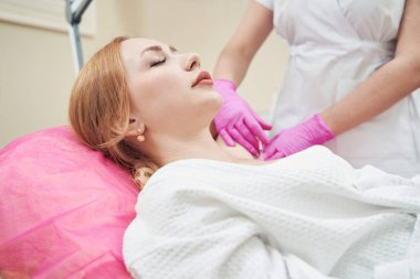 Zarif bir kadının portresi estetik klinikte aşırı terlemeyi önlemek için koltuk altı enjeksiyonu yaptırıyor.