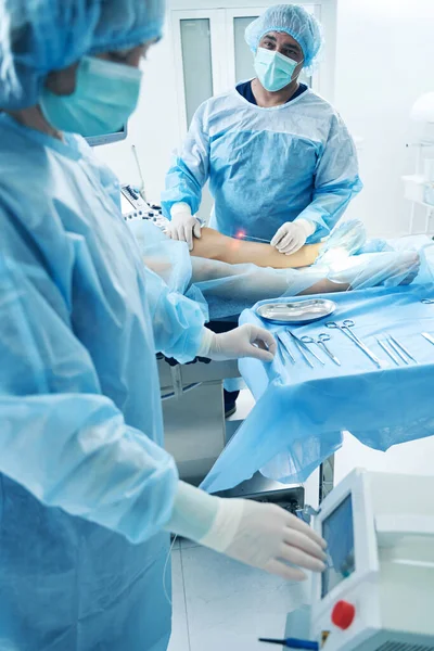 Ameliyat Salonundaki Doktorlar Lazer Tedavisi Sırasında Ameliyat Aletleriyle Masanın Yanında — Stok fotoğraf