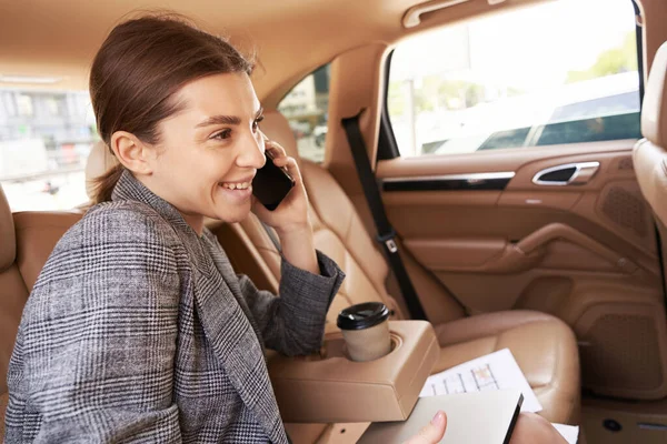 Neşeli Genç Bir Kadın Otomobilde Arka Koltukta Otururken Telefonla Konuşuyor — Stok fotoğraf