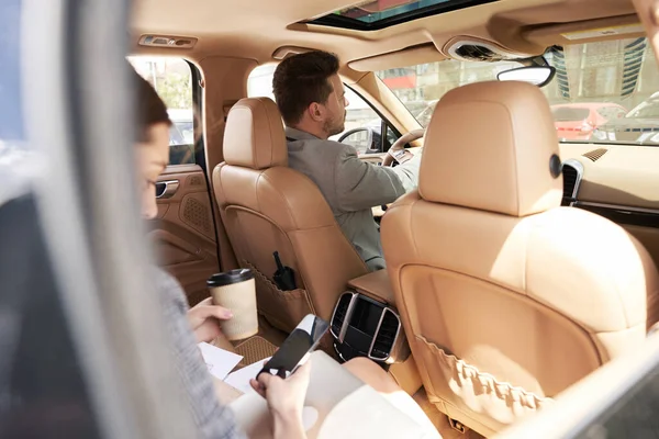 Kadın Elinde Kahve Fincanıyla Arabada Erkek Şoförle Otururken Akıllı Telefon — Stok fotoğraf