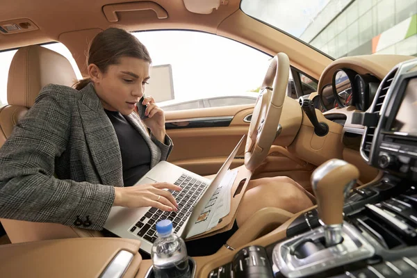 Kadını Otomobil Koltuğunda Otururken Telefonla Konuşuyor Klavyede Daktilo Kullanıyor — Stok fotoğraf