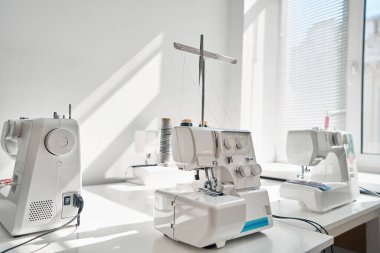 Moda atölyesinde terzi bekleyen giysiler yapmak için modern dijital ekipmanları kapatın