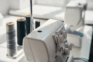 Masada duran ve atölyede terziyi bekleyen modern ekipman ve makaraların üst görüntüsü