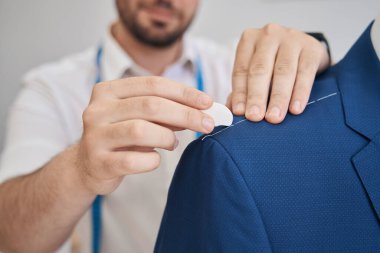 Yeni bir ceketin üzerine tebeşir kullanarak mezura ile gülümseyen bir adam kafası.