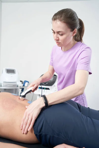 Fyzioterapeutka Masírující Muže Zpět Lékařským Ultrazvukovým Přístrojem — Stock fotografie