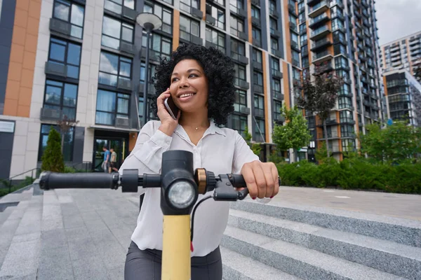 Smiling Multiracial Young Woman Talking Mobile Phone While Standing Scooter — 图库照片