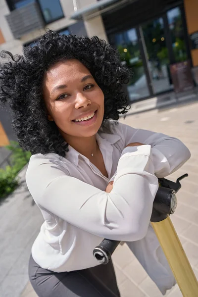 Happy Multiracial Female Standing Courtyard High Rise Building Leaning Scooter — Fotografia de Stock