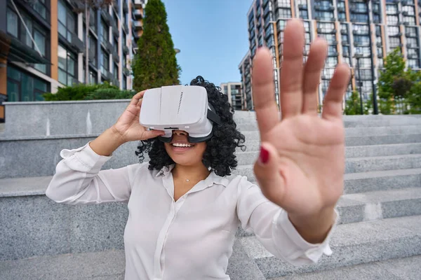 Smiling woman on city tour wearing virtual reality glasses