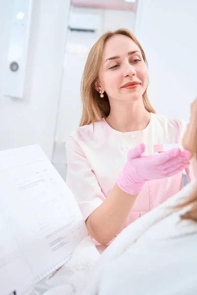 Concentrated Doctor Touches Face Patient Hands While She Sits Medical — Stockfoto