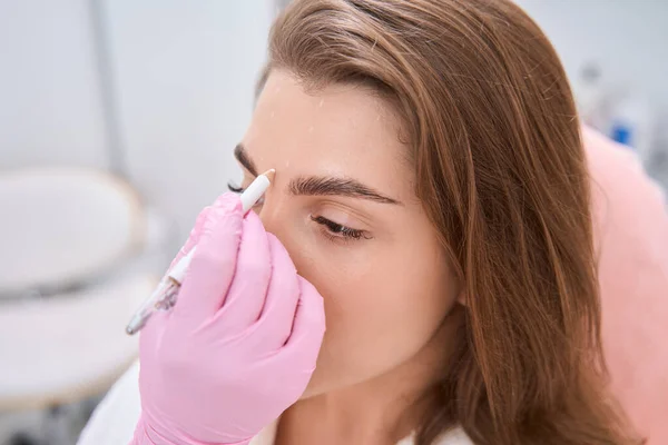 Focused Female Looking While Doctor Puts White Dots Her Face — Foto Stock