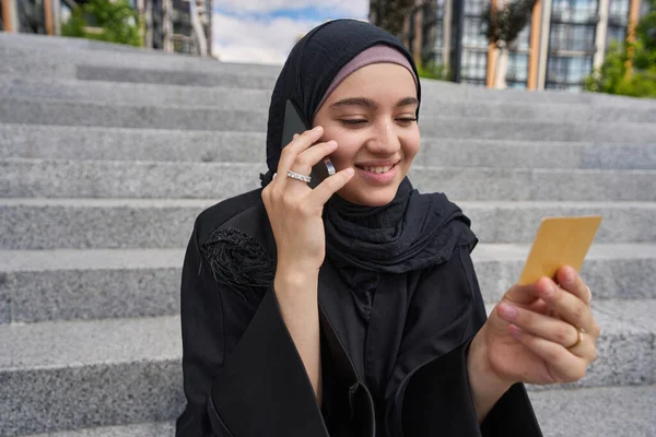 Muslim Woman Sitting Stairs Looking Business Card Talking Phone — 스톡 사진