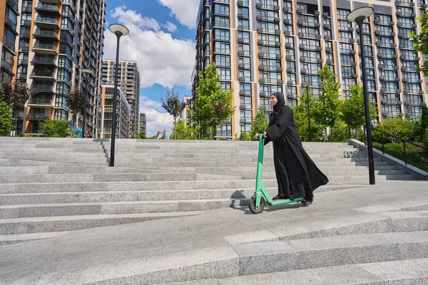 Muslim Woman Rides Green Scooter Backdrop Houses — 图库照片