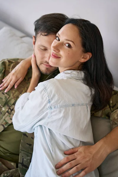 Woman Looking Back Camera While Lying Military Man Sofa Home — Fotografia de Stock