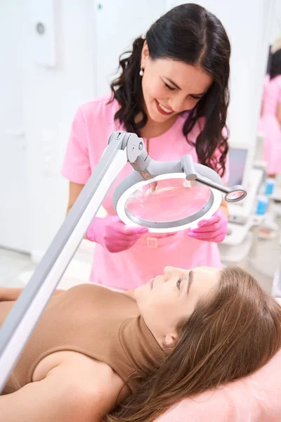 Smiling Cosmetologist Examines Skin Face While Patient Lies Medical Couch — Stockfoto