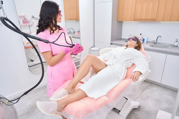 Focused Cosmetologist Protective Glasses Looks Lying Woman While Laser Adjusted — Fotografia de Stock