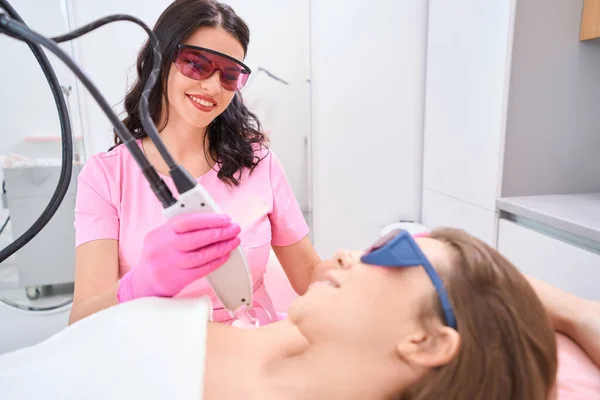 Smiling Doctor Sits Next Lying Patient While Holding Hair Removal — Stockfoto