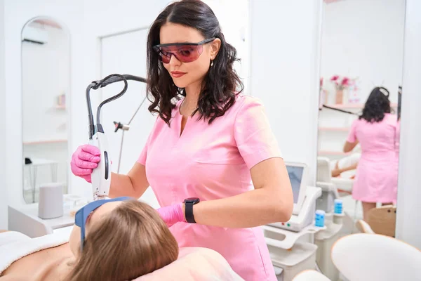 Serious Cosmetologist Stands Lying Patient While Her Hands Device Laser — Stockfoto