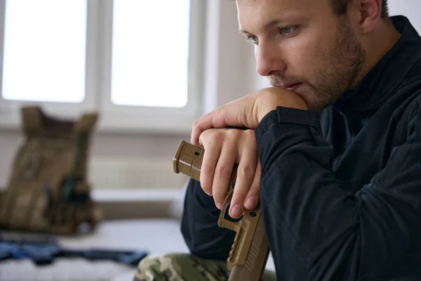 Caucasian Male Soldier Holding Pistol Hand While Sitting Appartment Staring —  Fotos de Stock